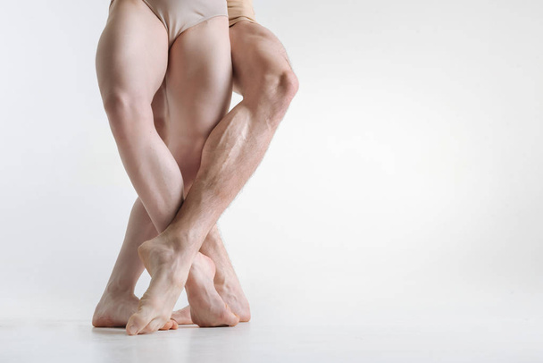 Athletic dancers legs located in the white colored room - Foto, imagen