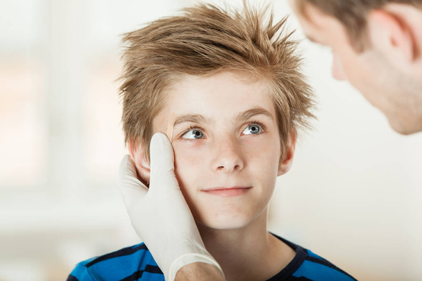 Young boy eye examination by doctor - Fotoğraf, Görsel