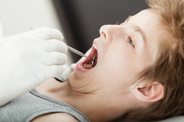 Young boy teeth examination by a dentist - Fotó, kép