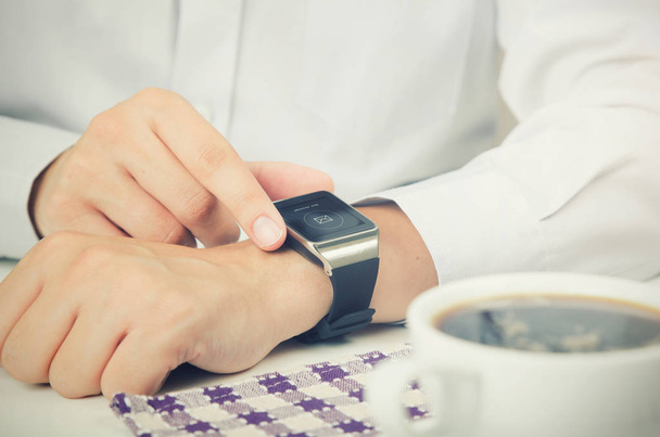 Businessman working with smart watch in restaurant - 写真・画像