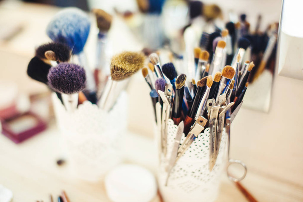 Makeup Brush in Glass Beaker on Dressing Table. - Фото, изображение
