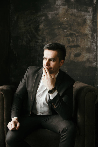 portrait of pensive businessman in suit sitting in velor armchair - Zdjęcie, obraz