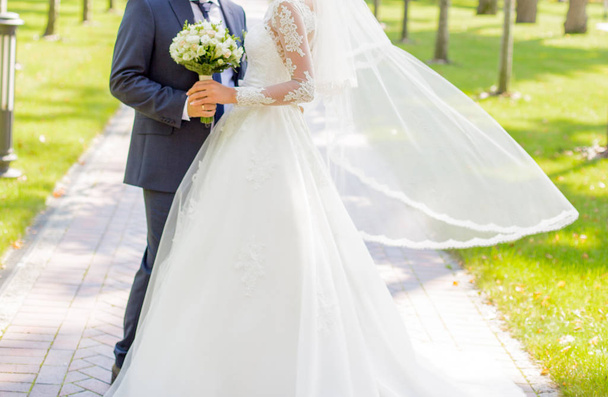 Bride and groom standing in the park - Φωτογραφία, εικόνα