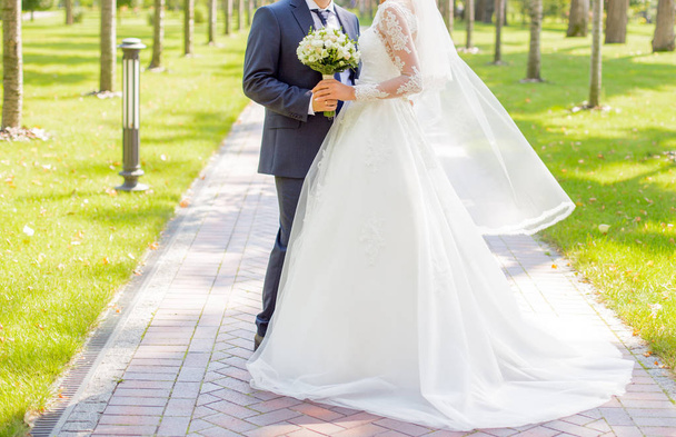 Bride and groom standing in the park - Foto, imagen