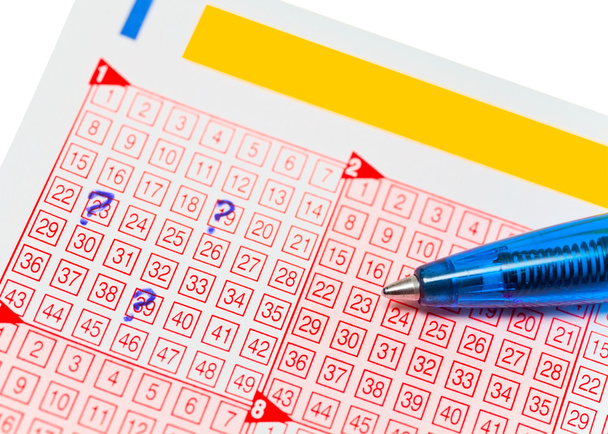 Biglietto del lotto con numeri segnati e una matita
 - Foto, immagini