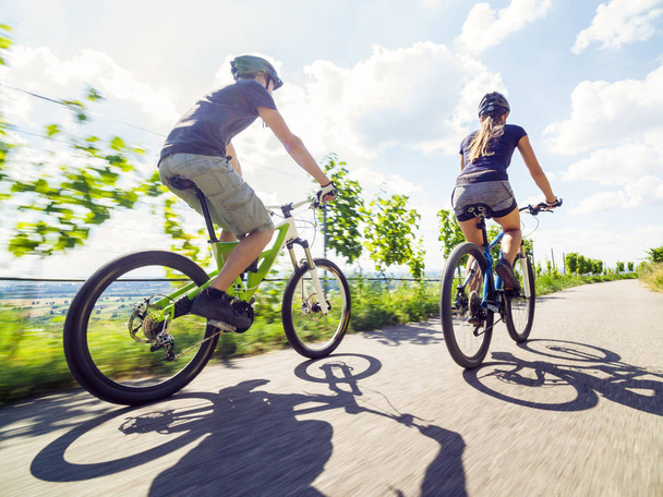 Jovem casal montando suas bicicletas de montanha
 - Foto, Imagem