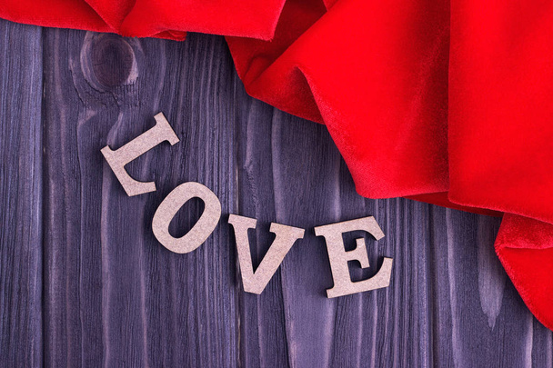 Valentine's day elegant still life with love lettering and red fabric on wooden background - Fotografie, Obrázek