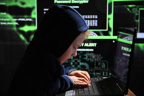 Jovem estudante prodígio - um hacker. Hacker no trabalho. Muitos dígitos na tela do computador
. - Foto, Imagem