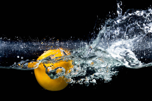 laranja salpicando água no fundo preto
 - Foto, Imagem