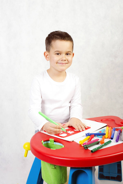 Boy draws sitting at the children's desk - Foto, immagini