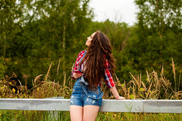Young beautiful brown haired woman in blue jeans  - Фото, изображение