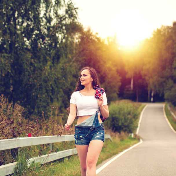 Young beautiful brown haired woman in blue jeans  - Valokuva, kuva