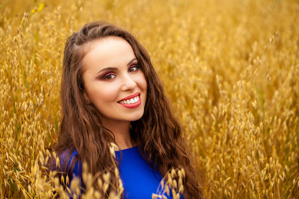 Portrait of a young girl on a background of golden wheat field - Foto, Imagem