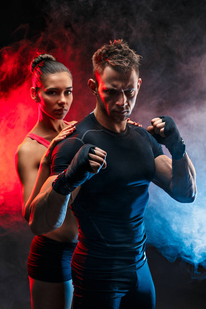 Strong boxer in stance with handwraps on his fists. With girlfriend standing behind him. - 写真・画像