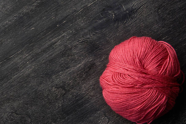 Single rose ball of yarn on wooden background of chalk board. - Фото, зображення