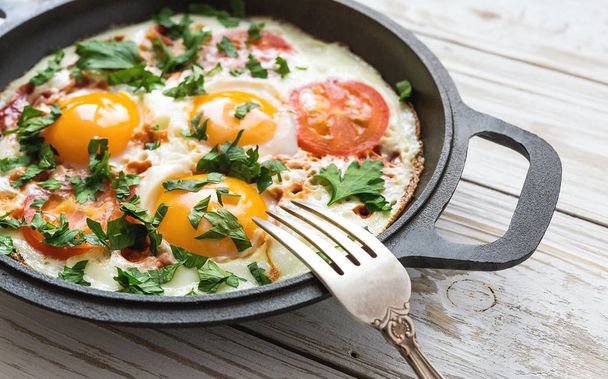 Pan of fried eggs, tomatoes and parsley with bread - Foto, Imagem