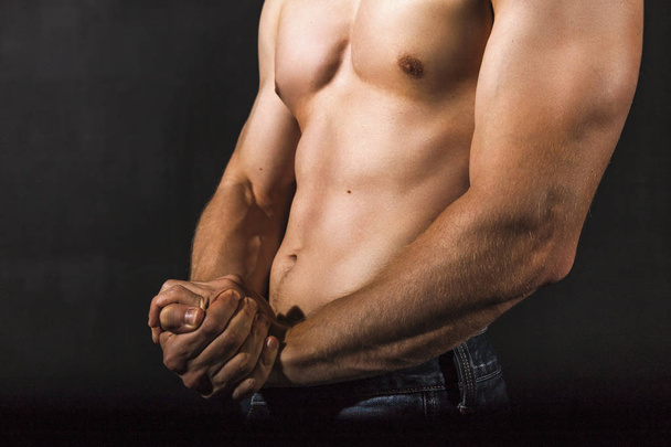 Jonge man met sterke armen en gespierde mannelijk torso - Foto, afbeelding