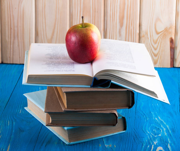 Пачка книг и свежее яблоко
  - Фото, изображение