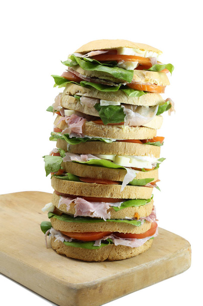 big sandwich with cheese ham tomato on a cutting board and white - Φωτογραφία, εικόνα