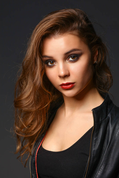 Portrait of beautiful brunette female wearing leather jacket - Photo, image