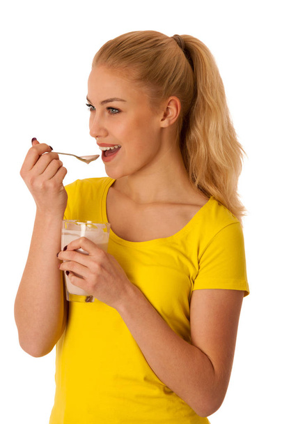Cute blonde woman eating fruit yogurt isolated over white background - Zdjęcie, obraz