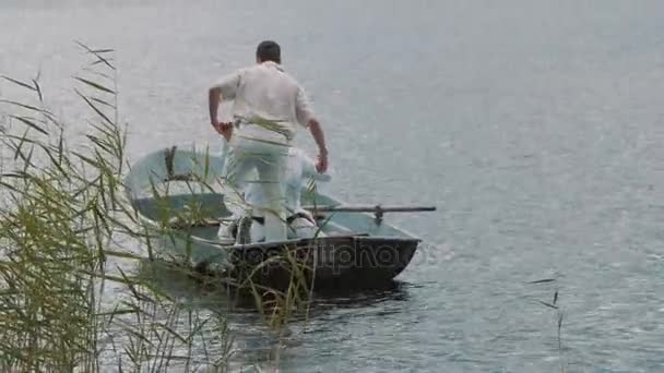 Homem de roupas brancas com megafone ajuda enfermeiros a sentar no barco verão dia ensolarado
 - Filmagem, Vídeo