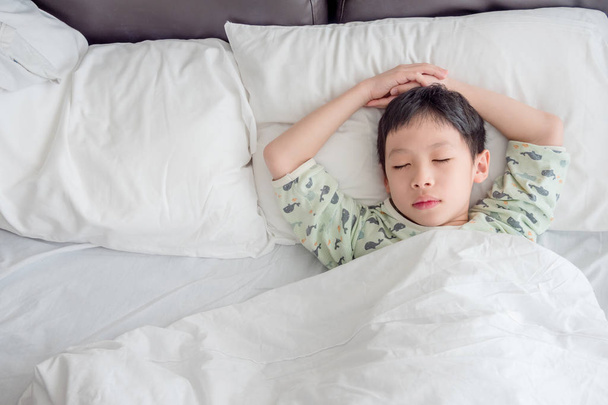 jongen slapen op bed in de ochtend - Foto, afbeelding
