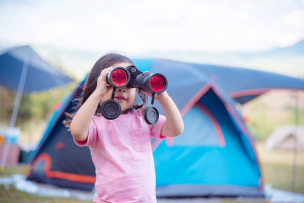 girl looking in binocular at camp - Photo, Image