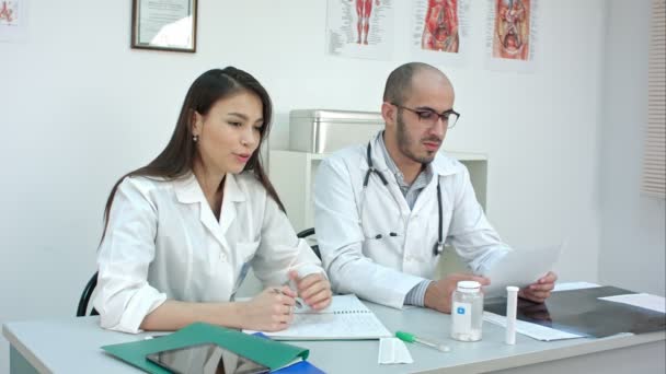 Pretty nurse and male doctor talking to the patient - Metraje, vídeo