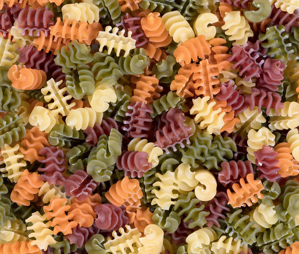 Colorful food background of raw twisted pasta - Photo, Image