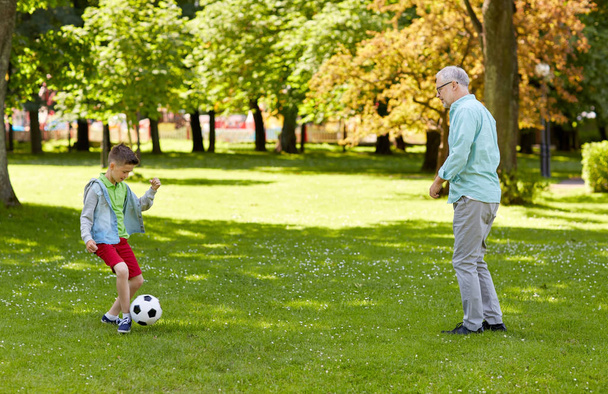 old man and boy playing football at summer park - Zdjęcie, obraz