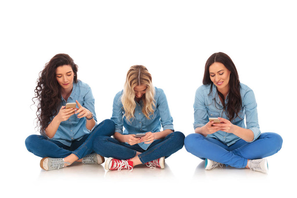 3 つのカジュアルな女性が座っているとテキスト メッセージ  - 写真・画像
