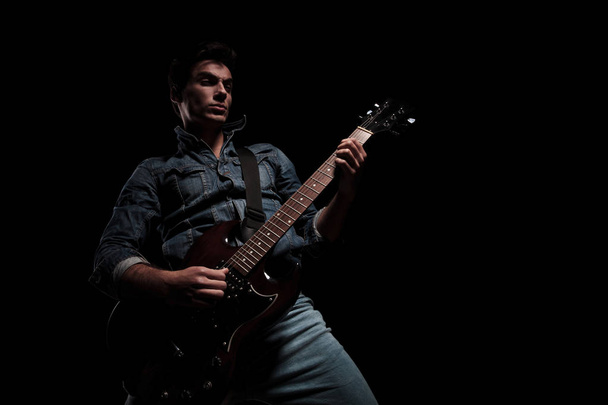 пристрасний молодий гітарист грає
  - Фото, зображення