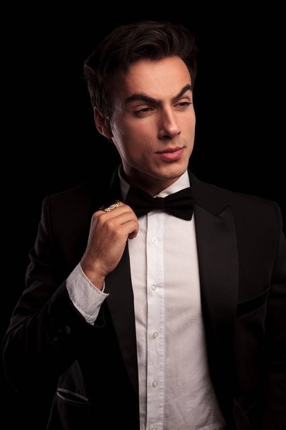 retrato de un hombre elegante en esmoquin fijando su corbata
 - Foto, Imagen