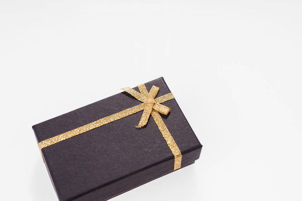 Black gift box with gold ribbon isolated - Fotoğraf, Görsel