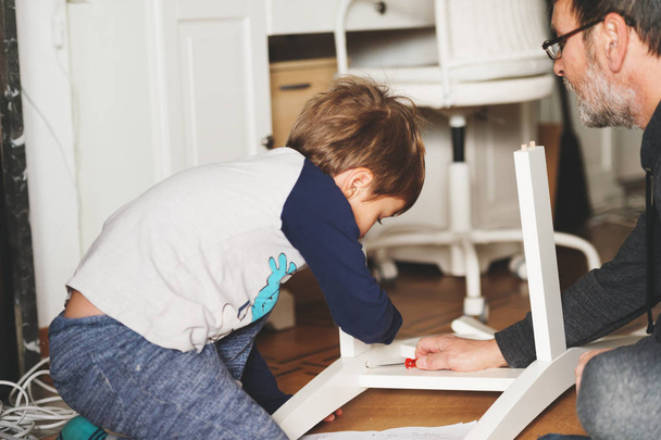 Father and son assembling  furniture together - Foto, imagen