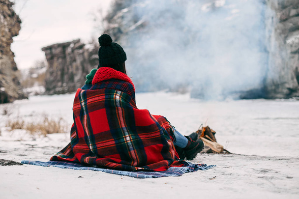 Couple sitting near a bonefire. They are covered with  warm blanket - Zdjęcie, obraz