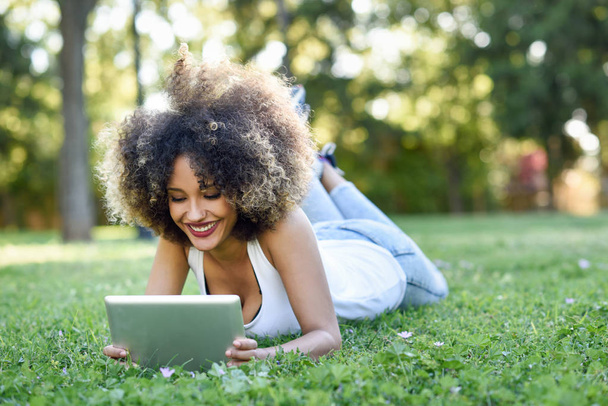 Tablet bilgisayar başında seyir afro saç modeli ile karışık kadın - Fotoğraf, Görsel