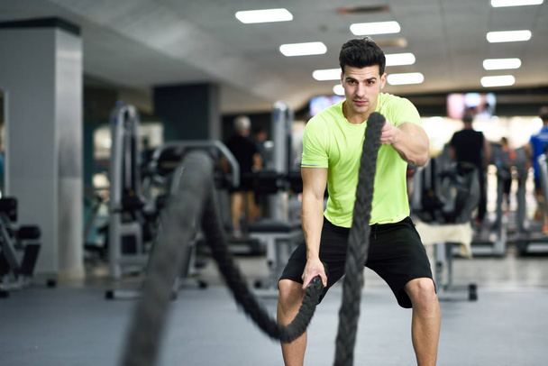 Homem com cordas de batalha exercitar no ginásio de fitness
. - Foto, Imagem