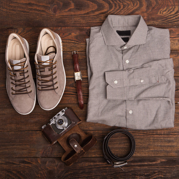 Плоская укладка современной мужской одежды на коричневом деревянном фоне
.  - Фото, изображение