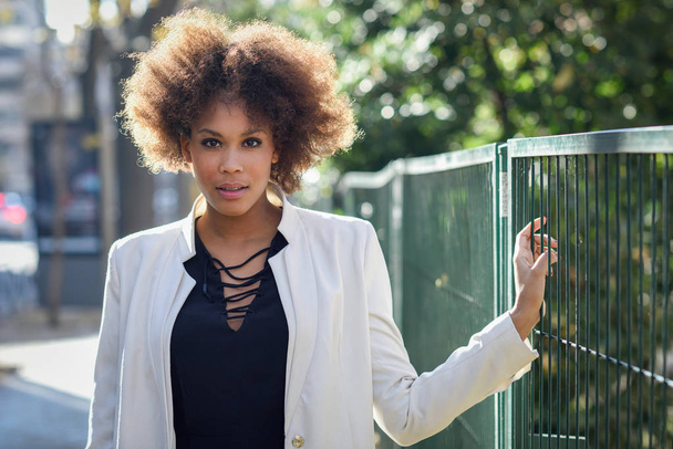 Giovane donna nera con acconciatura afro in piedi in backgrou urbano
 - Foto, immagini