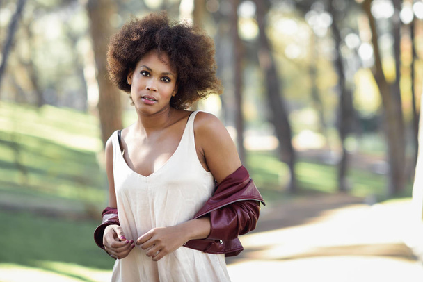 Молодая черная женщина с африканской прической, стоящая в городской заднице
 - Фото, изображение