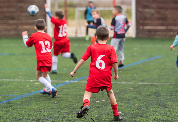  Jongens schoppen Voetbal op sportveld - Foto, afbeelding