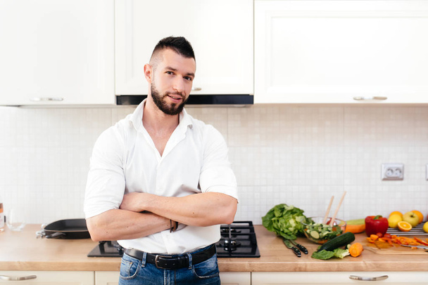 Male cooking and enjoying life in modern kitchen. Professional cook preparing salad - Foto, imagen