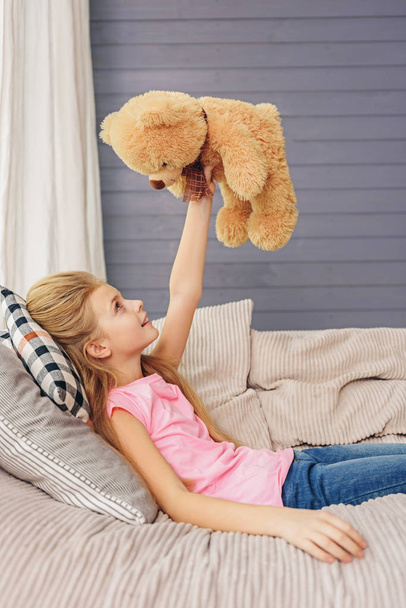 Cheerful kid having fun with soft toy - Foto, imagen