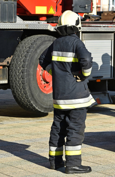 Firefighter stands next to a vehicle - Photo, Image