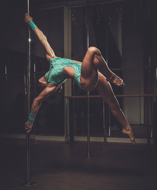 Beautiful woman performing pole dance on pole - Photo, Image