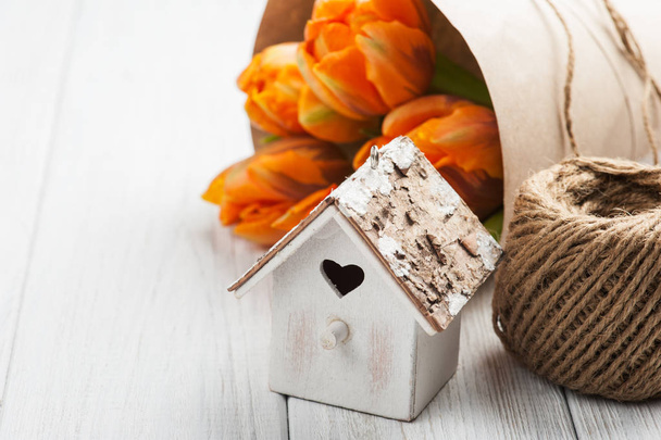 Oranje tulpen, houten hart vorm vogel huis en touw - Foto, afbeelding
