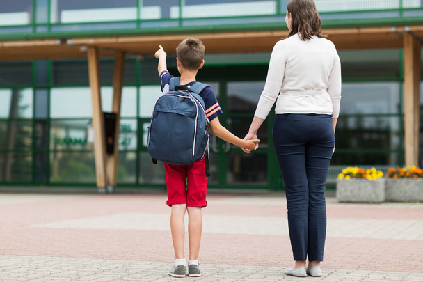 elementary student boy with mother at school yard - Photo, Image