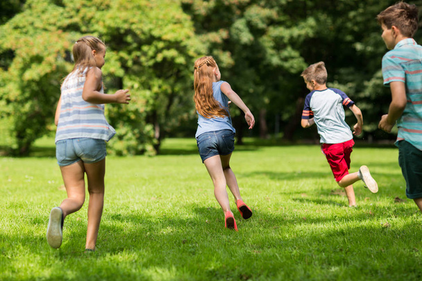 group of happy kids or friends playing outdoors - Photo, image